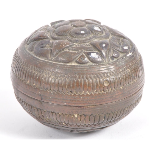 141 - A large Indonesian cast brass lime container. A spherical brass box, cast in two halves, decorated i... 