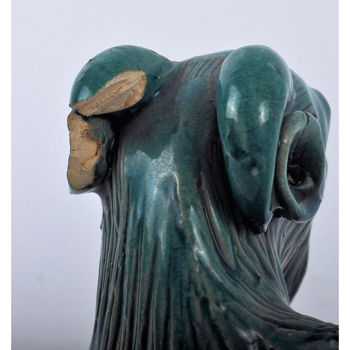 161 - A 19th Century Chinese monochrome pottery figurine depicting a Zodiac goat. Modelled reclined with e... 