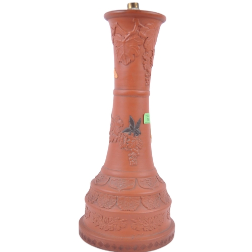 166 - A large 19th Century Chinese Yixing pottery lamp base. Tall waisted form with relief decoration depi... 