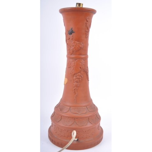 166 - A large 19th Century Chinese Yixing pottery lamp base. Tall waisted form with relief decoration depi... 