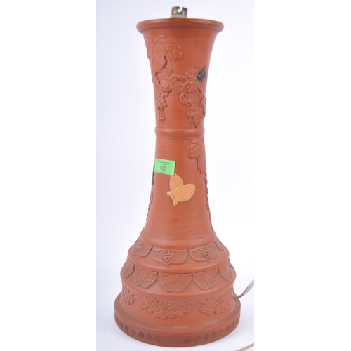166 - A large 19th Century Chinese Yixing pottery lamp base. Tall waisted form with relief decoration depi... 