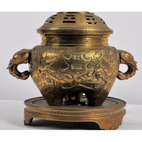171 - A Chinese twin handled bronze incense burner.   With asynchronous floral décor to surround, depictin... 