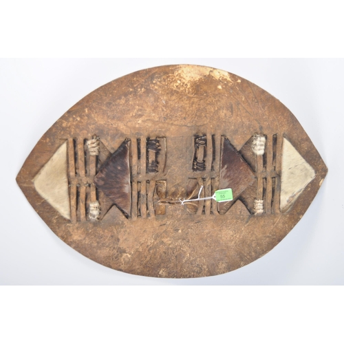 55 - A 19th Century African Tribal Zulu war shield. Hide construction and of typical form with pierced se... 