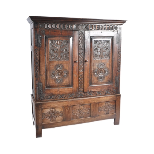 10 - A large 18th Century carved oak hall / livery cupboard armoire wardrobe. Flared carved cornice top w... 