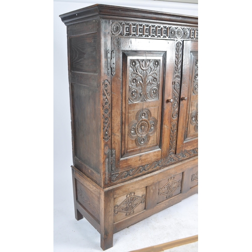 10 - A large 18th Century carved oak hall / livery cupboard armoire wardrobe. Flared carved cornice top w... 