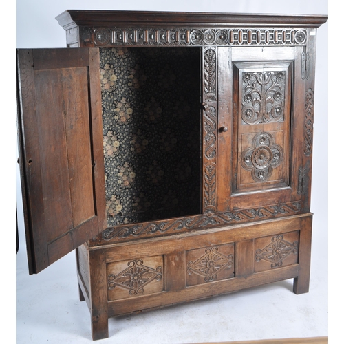 10 - A large 18th Century carved oak hall / livery cupboard armoire wardrobe. Flared carved cornice top w... 