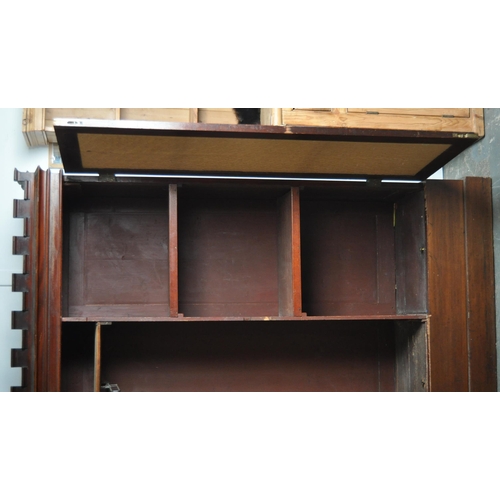 131 - A large 19th Century Victorian mahogany double door wardrobe of Gothic influence having a crenulated... 