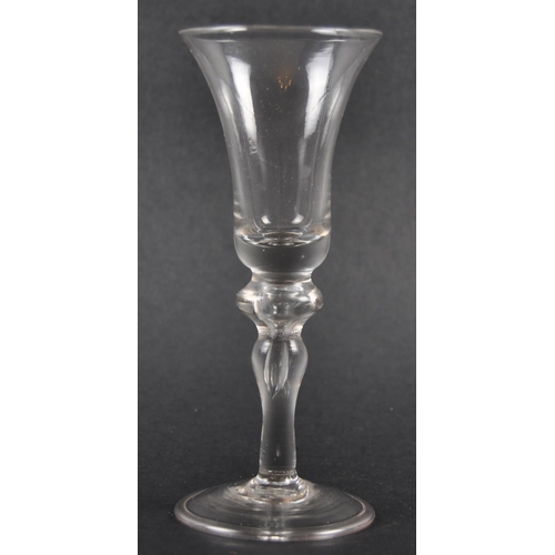 132 - An 18th Century George III baluster wine drinking glass having a bell shaped bowl with baluster air ... 