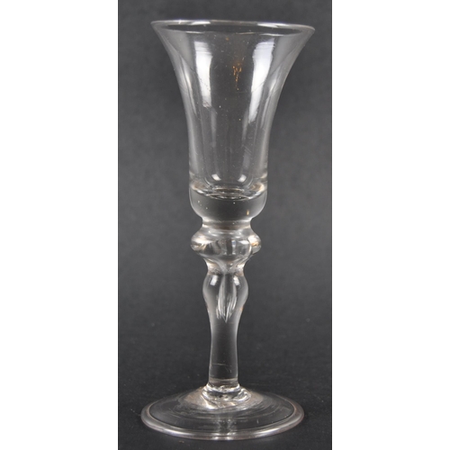 132 - An 18th Century George III baluster wine drinking glass having a bell shaped bowl with baluster air ... 