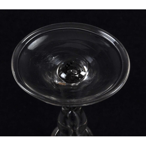 132 - An 18th Century George III baluster wine drinking glass having a bell shaped bowl with baluster air ... 