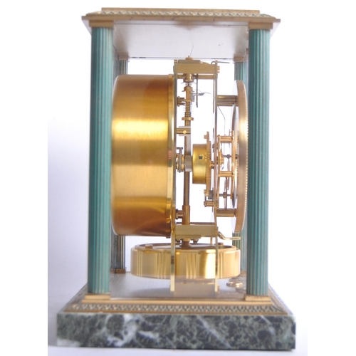 150 - A Jaeger LeCoultre Atmos clock, the glass and brass case with green enamel highlights and corner col... 