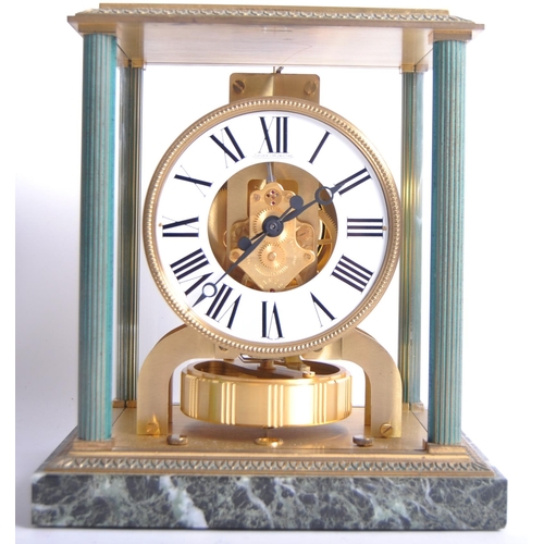 150 - A Jaeger LeCoultre Atmos clock, the glass and brass case with green enamel highlights and corner col... 