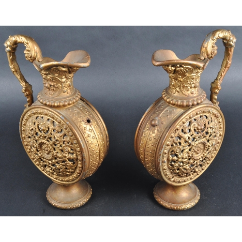 161 - A pair of early 20th Century gilt metal pilgrim flasks / ewer jugs. Lead interiors with pierced clas... 