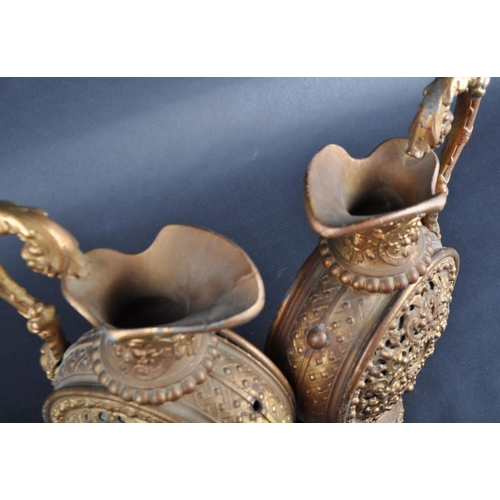 161 - A pair of early 20th Century gilt metal pilgrim flasks / ewer jugs. Lead interiors with pierced clas... 