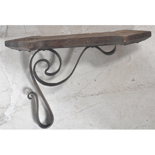 166 - A 19th Century wrought metal Arts & Crafts wrought metal wall light comprising a shaped metal wall a... 