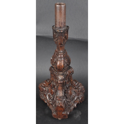 183 - An early 18th century oak carved church altar candle holder. Of triangular form, with floral and scr... 