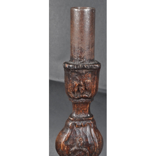 183 - An early 18th century oak carved church altar candle holder. Of triangular form, with floral and scr... 