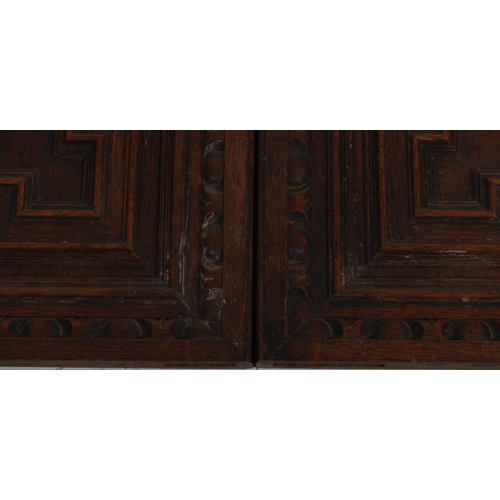 207 - A pair of 19th Century carved oak panel doors of geometric form. Central carved face with intricate ... 