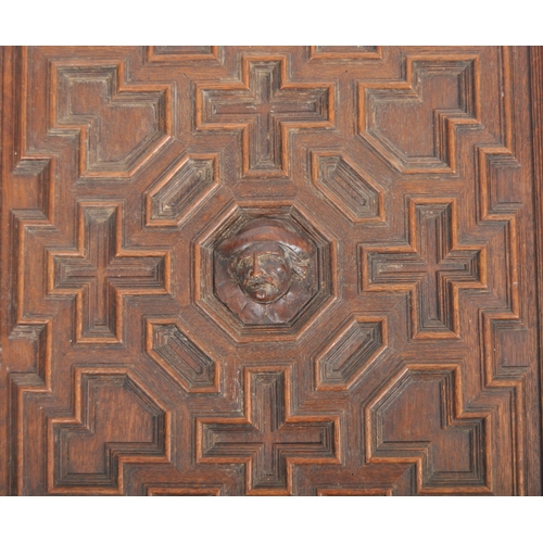 207 - A pair of 19th Century carved oak panel doors of geometric form. Central carved face with intricate ... 