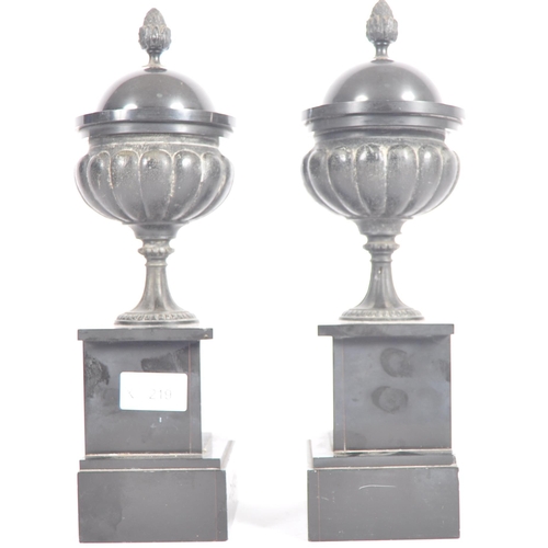 219 - A pair of 19th Century Grand Tour bronze classical lidded urns having acorn finial tops, reeded bodi... 