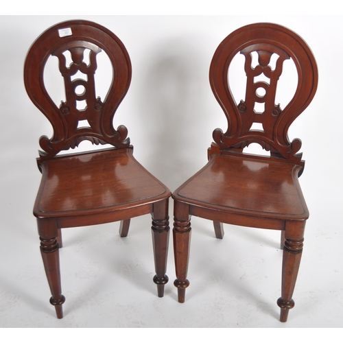 221 - A matching pair of 19th Century Victorian mahogany hall chairs having shaped armorial backrest with ... 