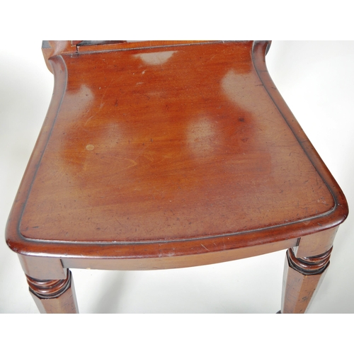 221 - A matching pair of 19th Century Victorian mahogany hall chairs having shaped armorial backrest with ... 