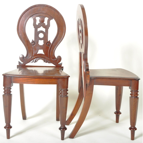 221 - A matching pair of 19th Century Victorian mahogany hall chairs having shaped armorial backrest with ... 