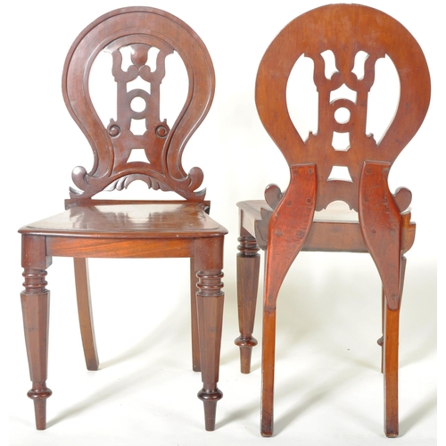 221 - A matching pair of 19th Century Victorian mahogany hall chairs having shaped armorial backrest with ... 