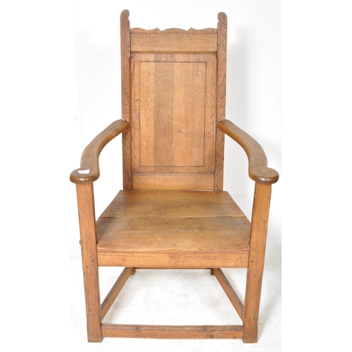 229 - A 19th Century Arts & Crafts solid oak armchair / throne chair having a panelled backrest with shape... 