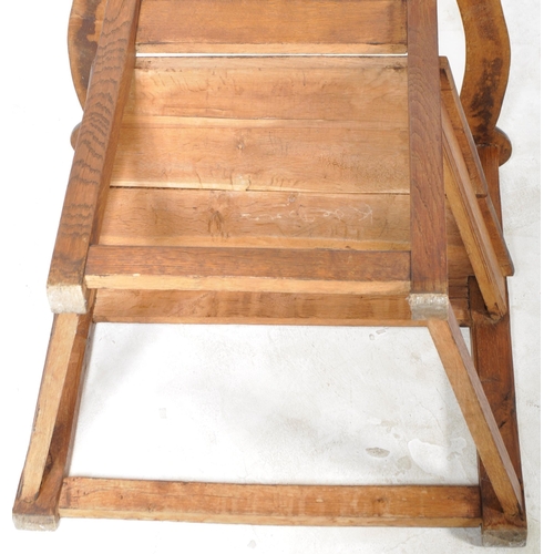 229 - A 19th Century Arts & Crafts solid oak armchair / throne chair having a panelled backrest with shape... 