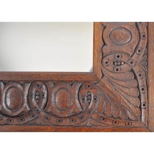 230 - A 19th Century Victorian arts & crafts carved oak mirror. Decorated with repeated floral patterns an... 