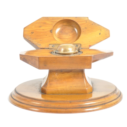 252 - An early 20th Century olivewood inkwell / desk stand. With a hinged lid opening to reveal a circular... 