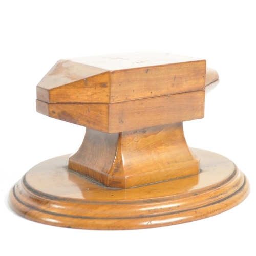 252 - An early 20th Century olivewood inkwell / desk stand. With a hinged lid opening to reveal a circular... 