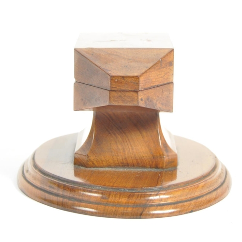 252 - An early 20th Century olivewood inkwell / desk stand. With a hinged lid opening to reveal a circular... 