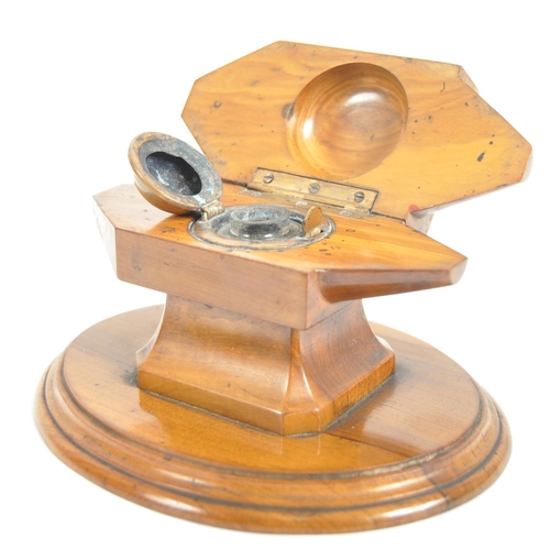 252 - An early 20th Century olivewood inkwell / desk stand. With a hinged lid opening to reveal a circular... 