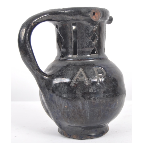 27 - An 18th Century Georgian pottery puzzle jug. Black painted finish with incised 1741 to globular body... 