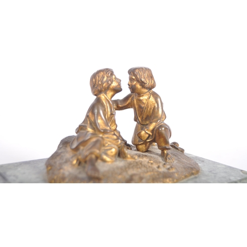 273 - A 19th Century gilt bronze figurine group depicting two boys playing a dice game. Set to a green mar... 