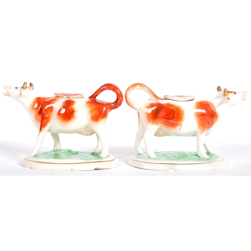 315 - A pair of 19th Century Staffordshire pottery cow milk creamer jugs. Painted decoration and raised on... 