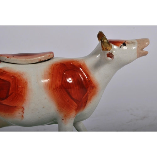 315 - A pair of 19th Century Staffordshire pottery cow milk creamer jugs. Painted decoration and raised on... 