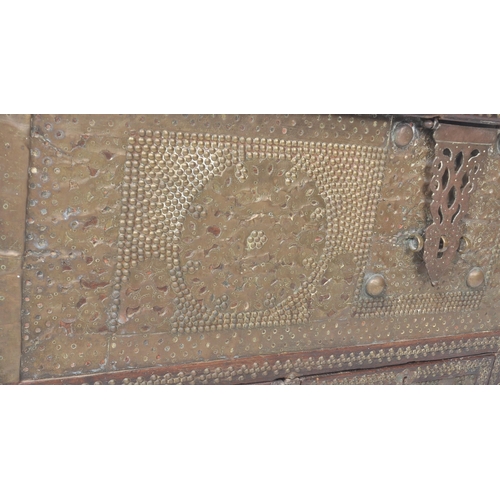 321 - A large 19th Century teak brass studded Zanzibar trunk. The front panel intricately decorated with b... 