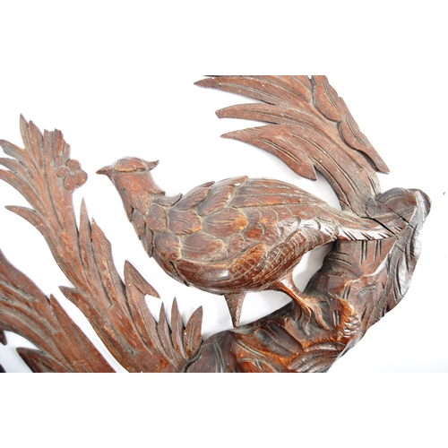 353 - A pair early 20th Century carved oak black forest wall plaques in the form of birds. Central pheasan... 