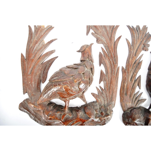 353 - A pair early 20th Century carved oak black forest wall plaques in the form of birds. Central pheasan... 