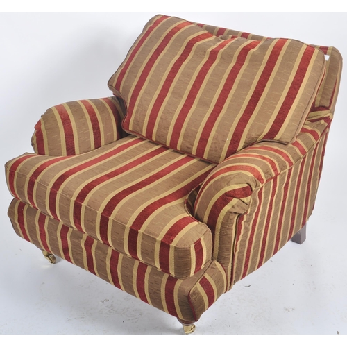 39 - A 20th Century deep armchair / arm chair in the manner of Howard & Sons. Deep cushioned seat and bac... 