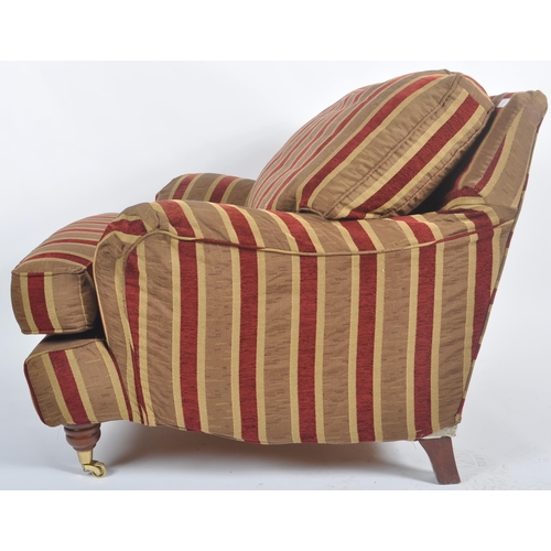 39 - A 20th Century deep armchair / arm chair in the manner of Howard & Sons. Deep cushioned seat and bac... 