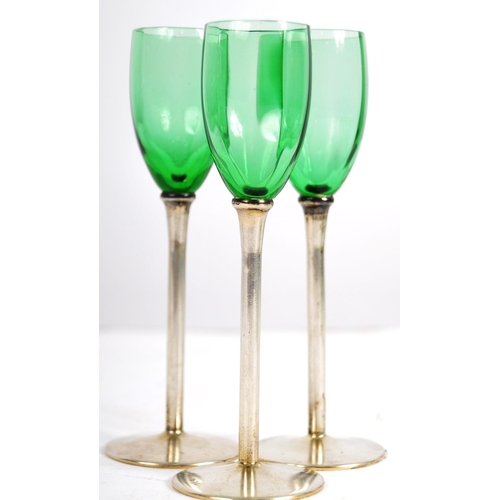 393 - A set of six early 20th Century green glass and silver based liquor drinking glasses. Gently faceted... 