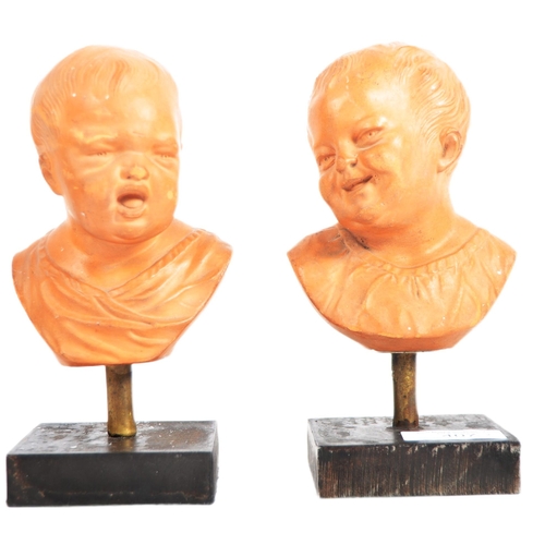 407 - A pair of 19th Century terracotta busts / portrait studies depicting infants / cherub puttis. Orange... 