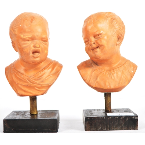 407 - A pair of 19th Century terracotta busts / portrait studies depicting infants / cherub puttis. Orange... 