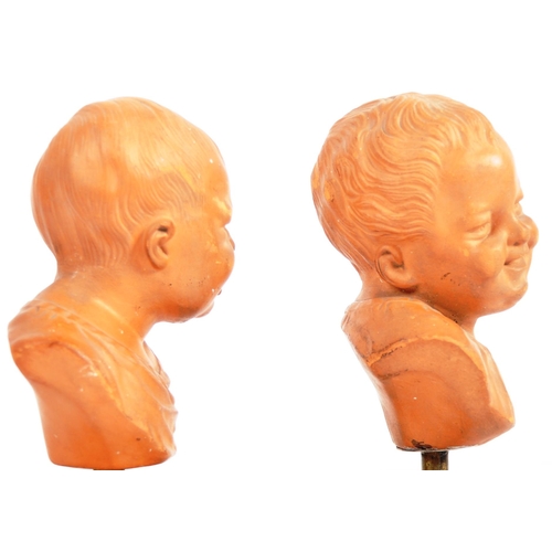 407 - A pair of 19th Century terracotta busts / portrait studies depicting infants / cherub puttis. Orange... 