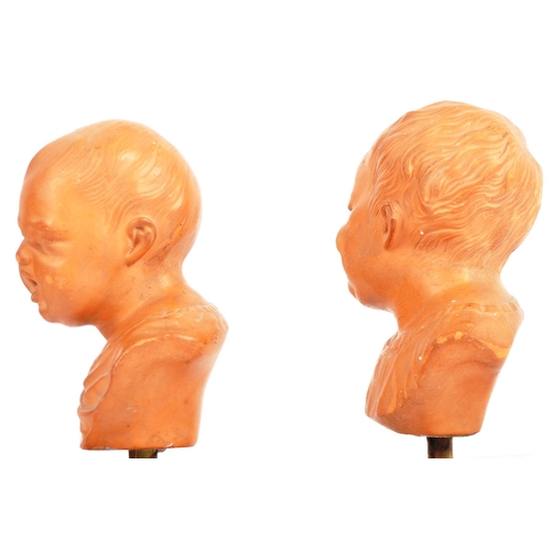 407 - A pair of 19th Century terracotta busts / portrait studies depicting infants / cherub puttis. Orange... 