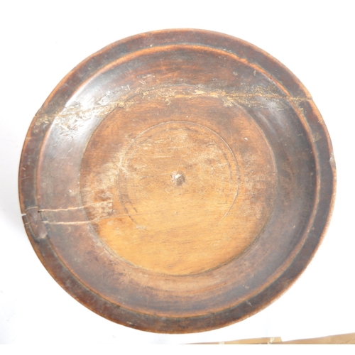 418 - A 17th century English church collection treen plate. A carved raised edge rim plate supported on ra... 